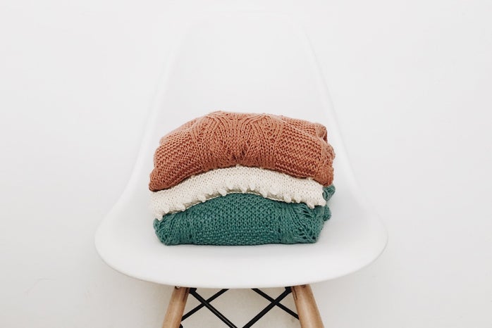3 sweaters on white chair