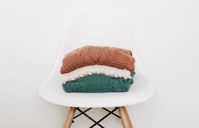 3 sweaters on white chair