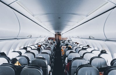 The inside of a plane. Many seats are packed closely together.