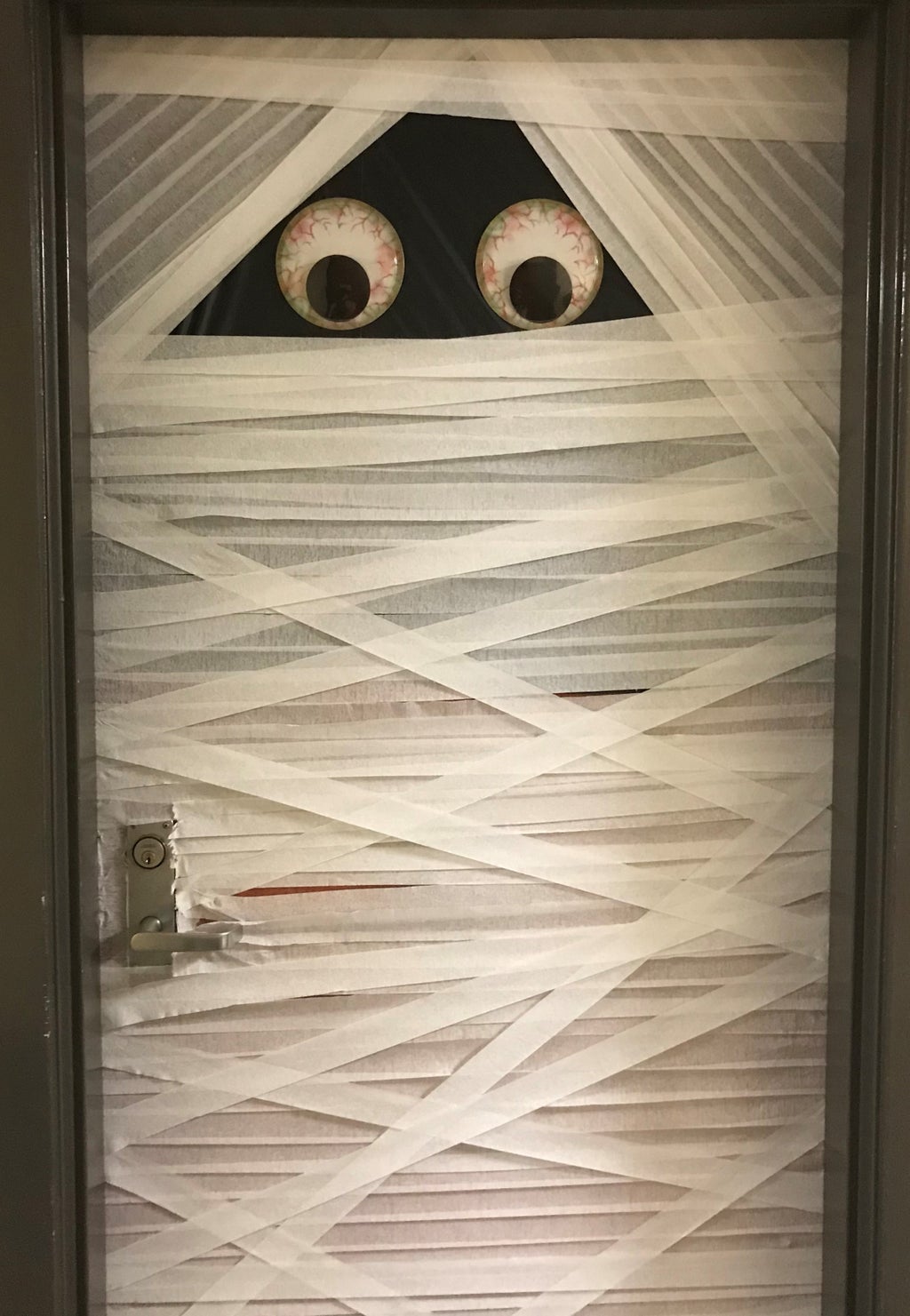 A decorated door with two big eyes made to look like a mummy