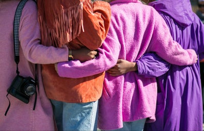Four people holding each other in shades of purple