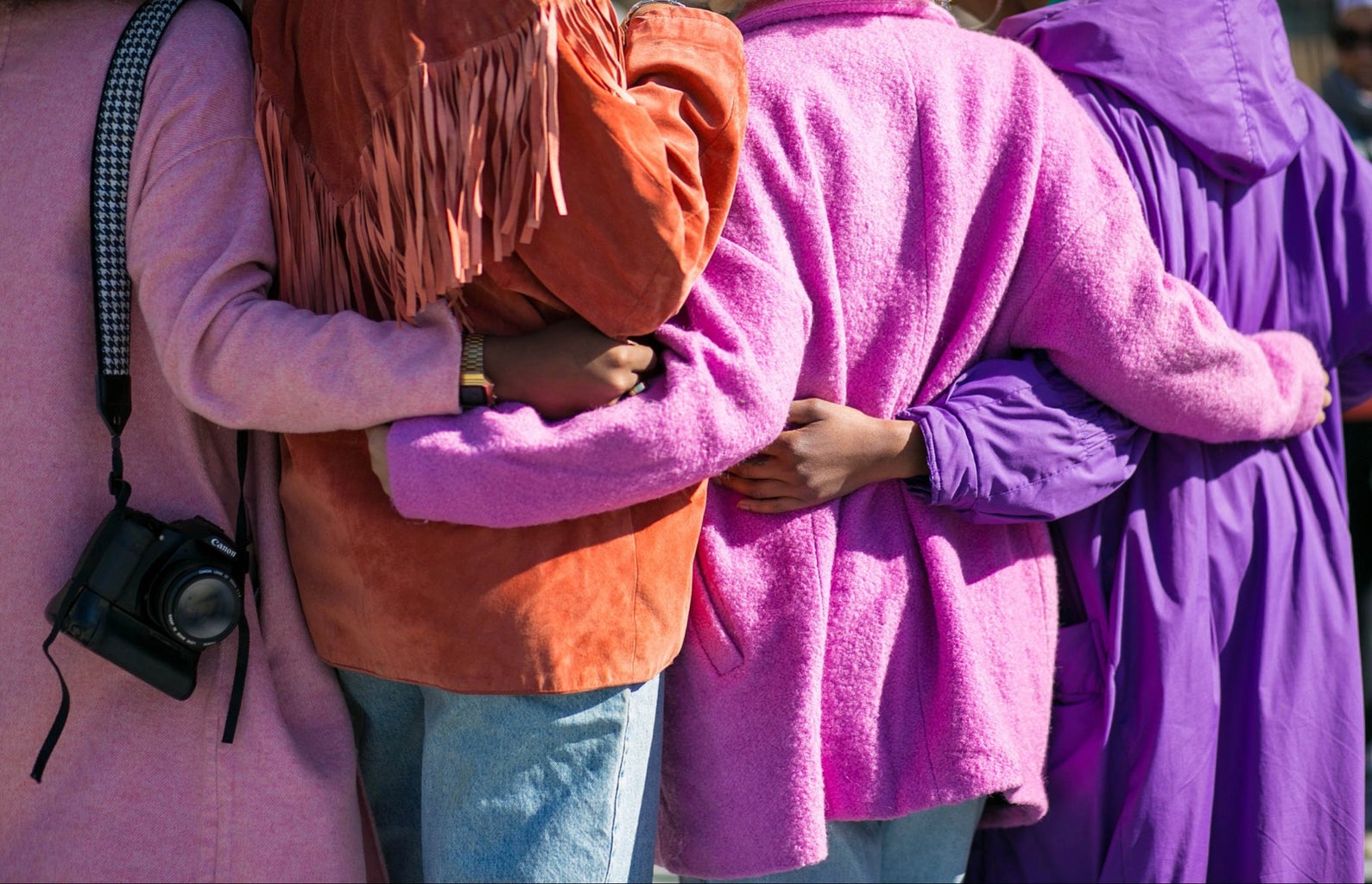 Four people holding each other in shades of purple