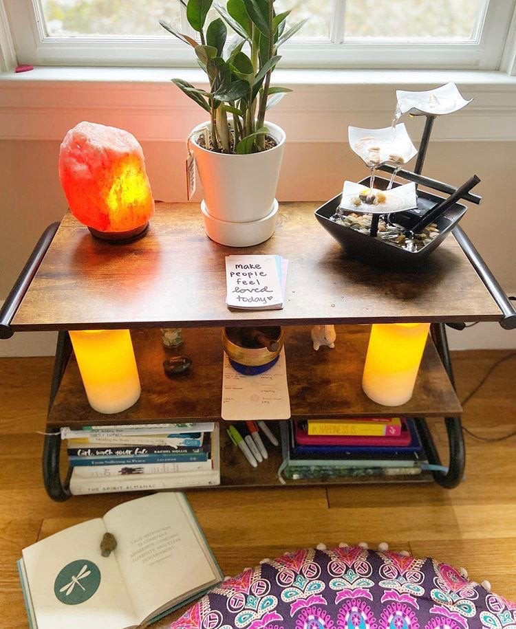 Meditation corner/altar with candles, books, a plant, a fountain