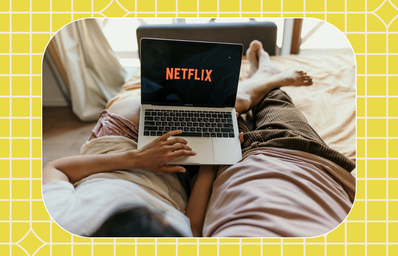 couple on bed watching netflix on laptop