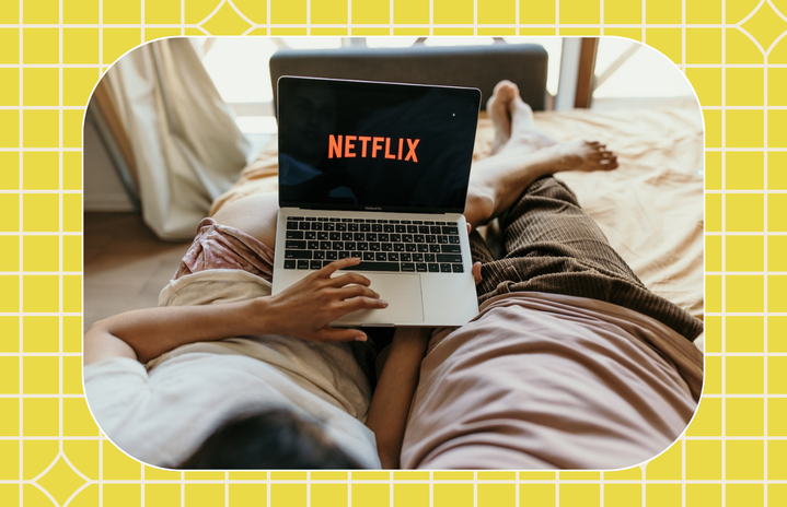 couple on bed watching netflix on laptop
