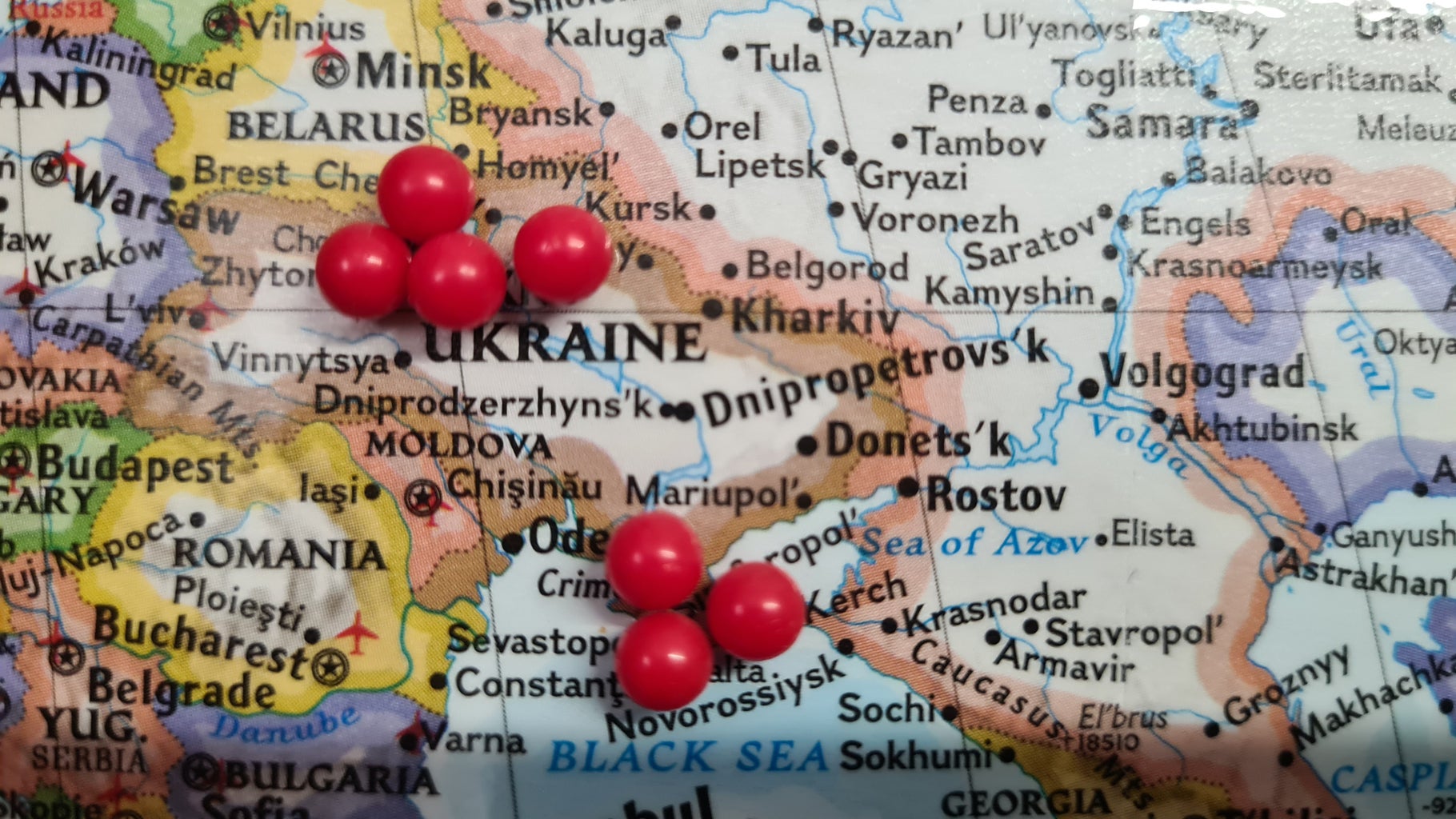 map of the world with thumbtacks pinned on Ukraine