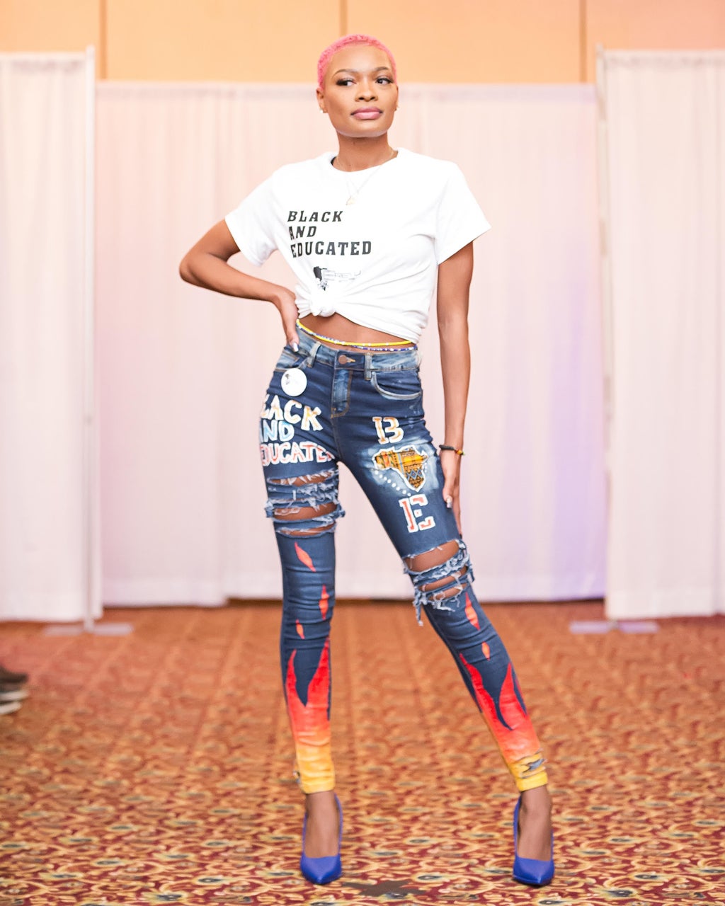 female model wearing a white \"black and educated\" shirt with designer jeans.