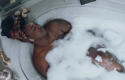 woman in bubble bath relaxing eyes closed