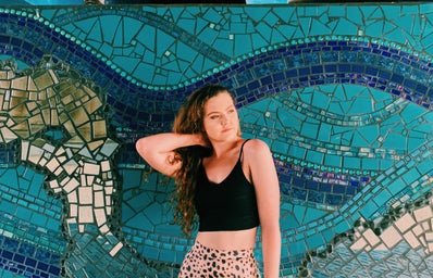 Becca McCandless in front of blue mosaic mural