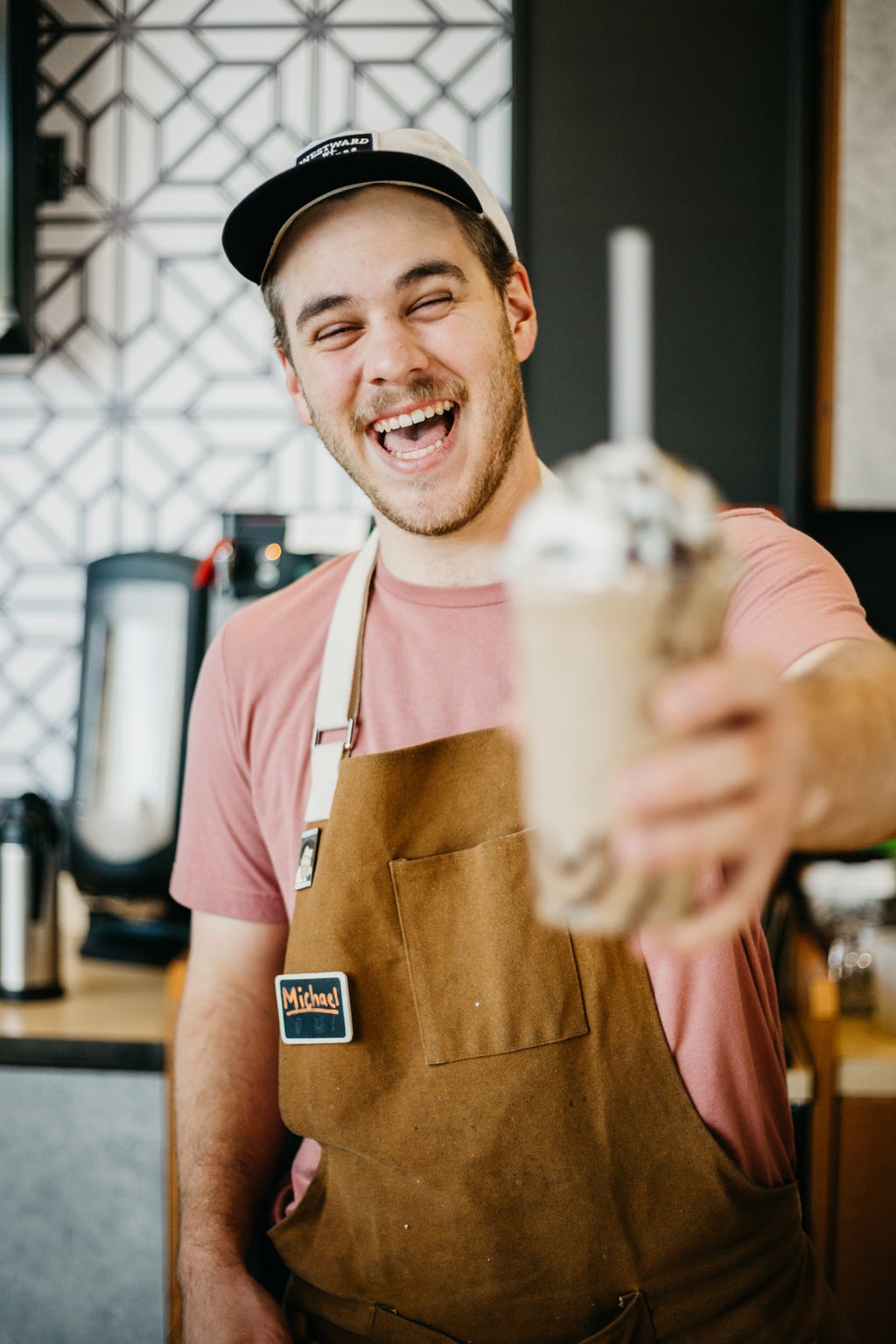 Man holding a smoothie and smiling.