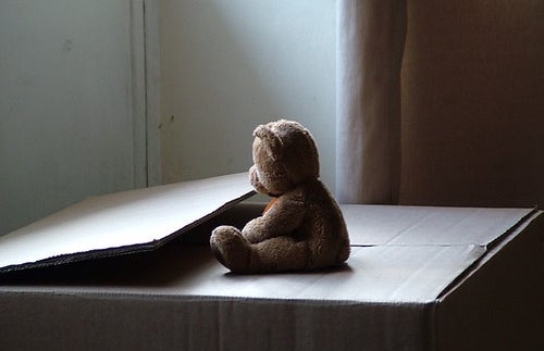 Sad teddy bear on moving box