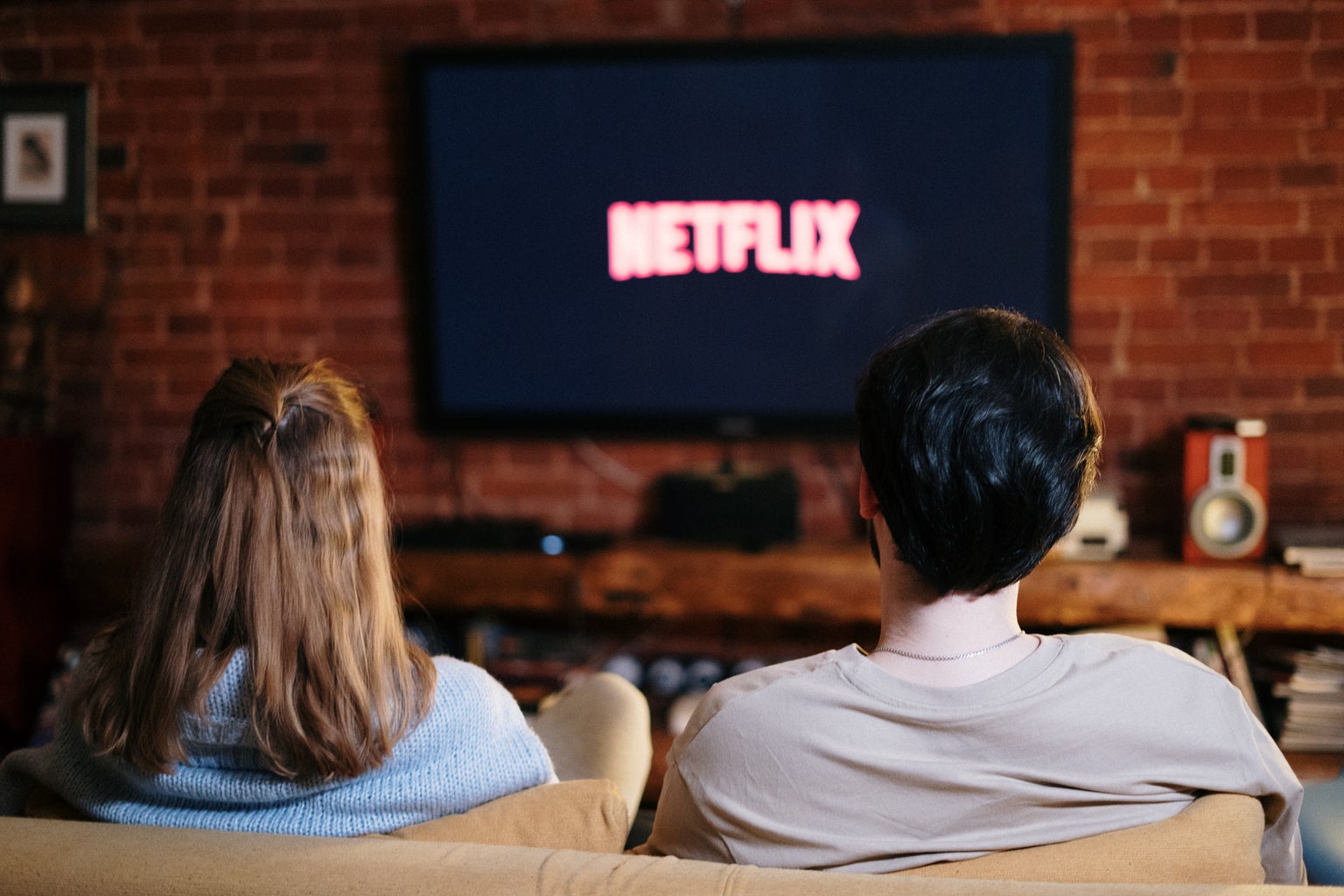 couple sitting on couch watching Netflix