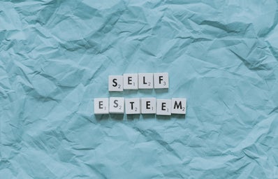 SELF ESTEEM written in Scrabble letters against a blue background