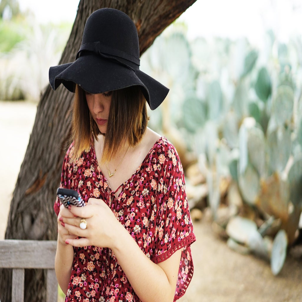 texting hat girl cactus bench floral shirt