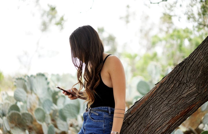 kellyn simpkins girl scrolling phone high waisted jeans watch curly hair cactus?width=719&height=464&fit=crop&auto=webp