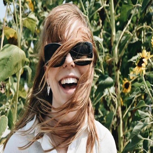 happy girl smile hair blowing windy sunflowers red hair