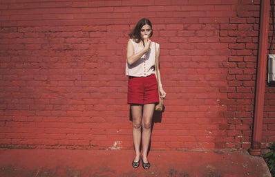 girl in front of red brick wall eating ice cream 1