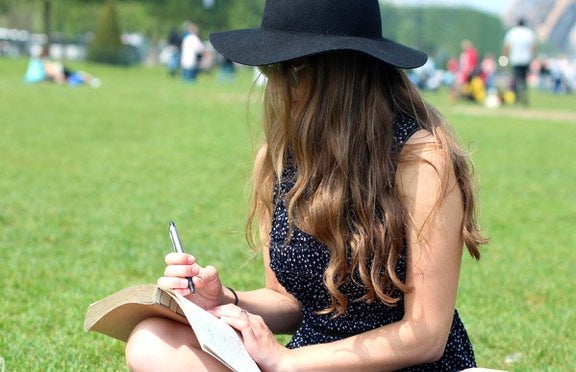Kellyn Simpkin hat girl writing book grass outside?width=719&height=464&fit=crop&auto=webp