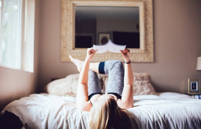 Girl Reading A Book In Bed