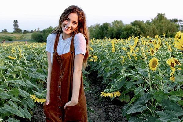 Maria Scheller brunette happy girl sunflower field dress hands in pockets?width=698&height=466&fit=crop&auto=webp