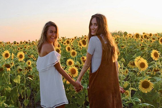 Maria Scheller best friends holding hands sunflower field dresses summer happy sunset?width=698&height=466&fit=crop&auto=webp