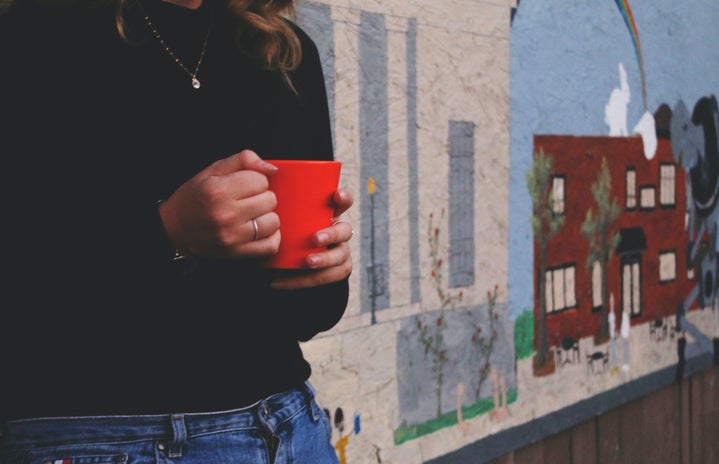 The Lalagirl Holding Mug In Front Of Mural