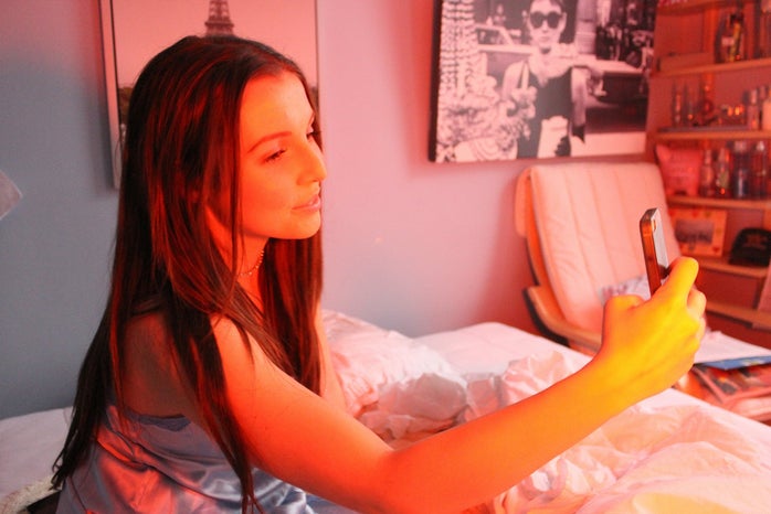 Anna Schultz girl taking selfie in bed orange lighting?width=698&height=466&fit=crop&auto=webp