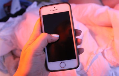 Anna Schultz-Hand Holding Iphone In Pink Lighting
