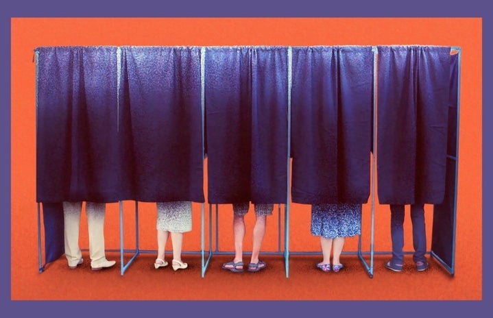 People standing inside of blue material voter polls