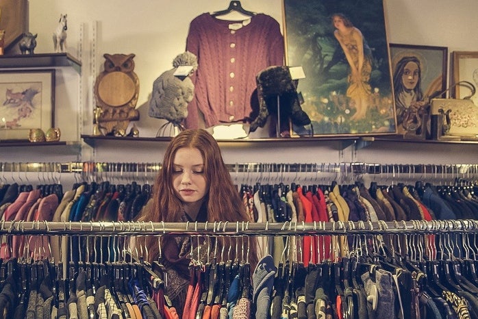 Young woman looking at different racks of clothes at a store.