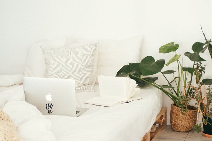 Turned On Silver Macbook On White Bed