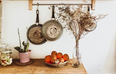 Two Gray Frying Pans Hanging On Wall