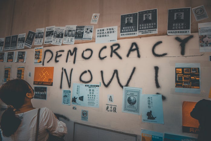 person looking at wall with democracy now! text