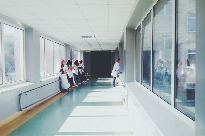 There are doctors standing in the hallway of a hospital.