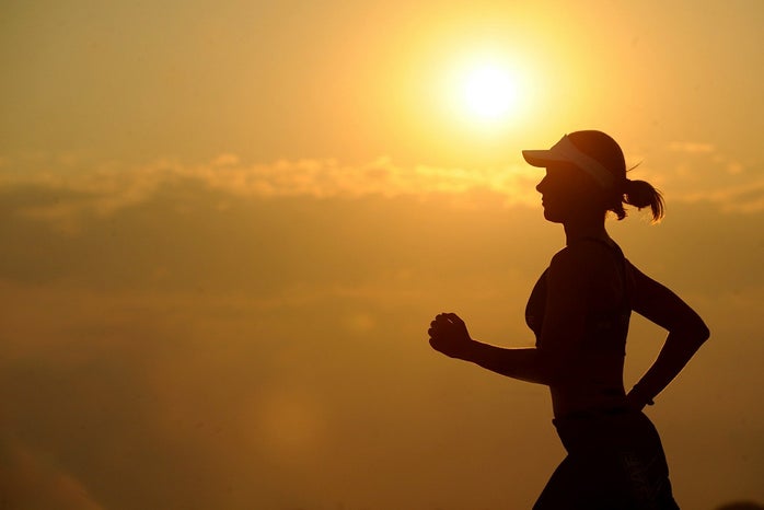 Woman running with a sunset in the background