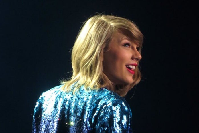 Taylor Swift on stage in colorful jacket