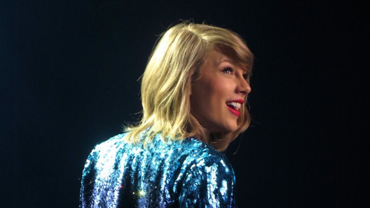 Taylor Swift on stage in colorful jacket