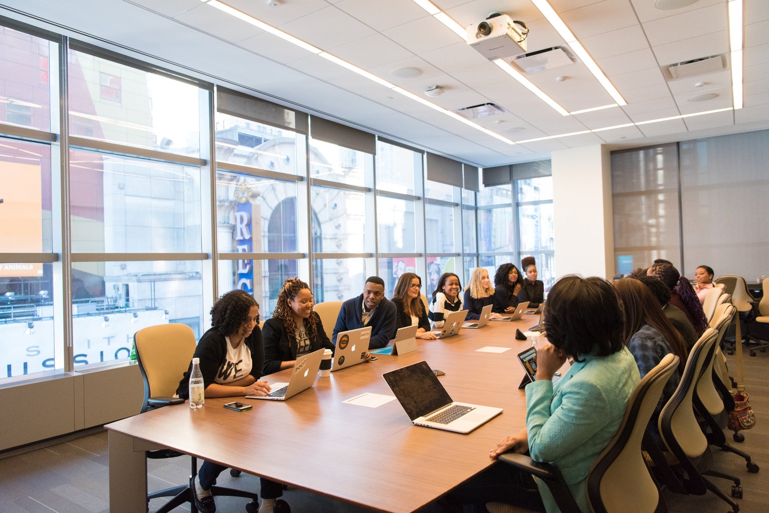 group of people working side by side at table with laptops