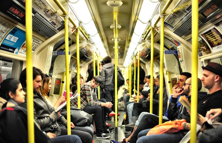 group of people sitting on a crowded train