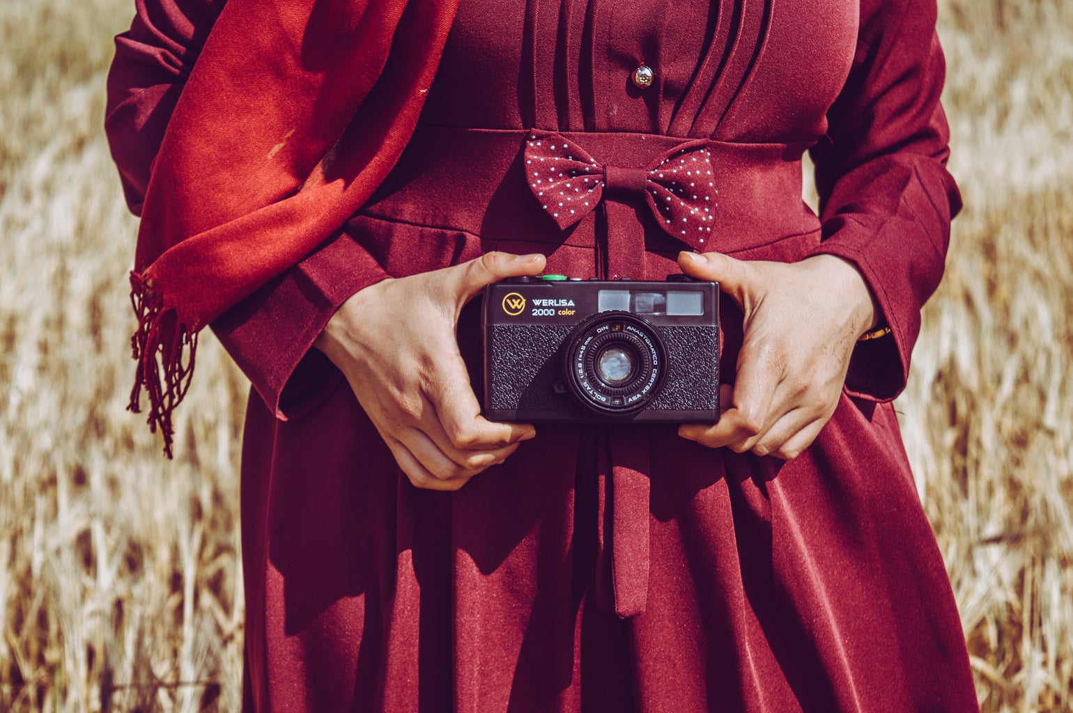 person wearing red holding camera