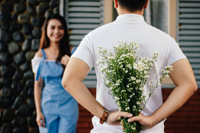 Boy hiding flowers for girl