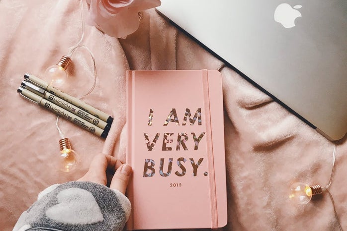 Silver macbook by planner and flowers