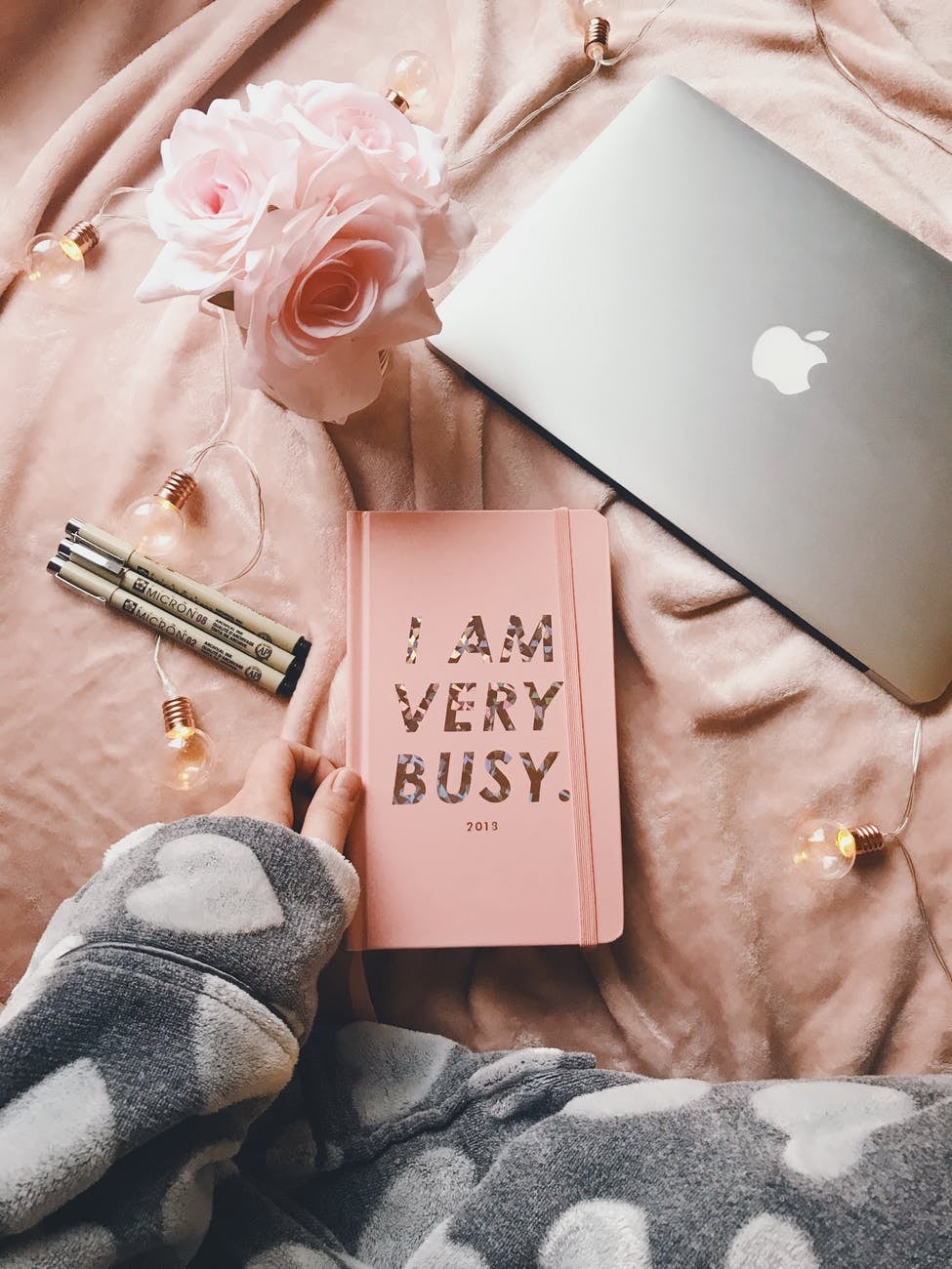 Silver macbook by planner and flowers