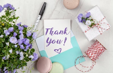 thank you note with pen, gift, cookies, and flowers
