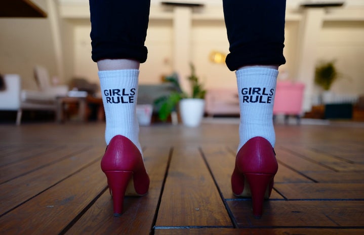 woman wearing red high heels with white socks that say girls rule