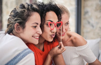 3 women posing for photo together, one with heart glasses