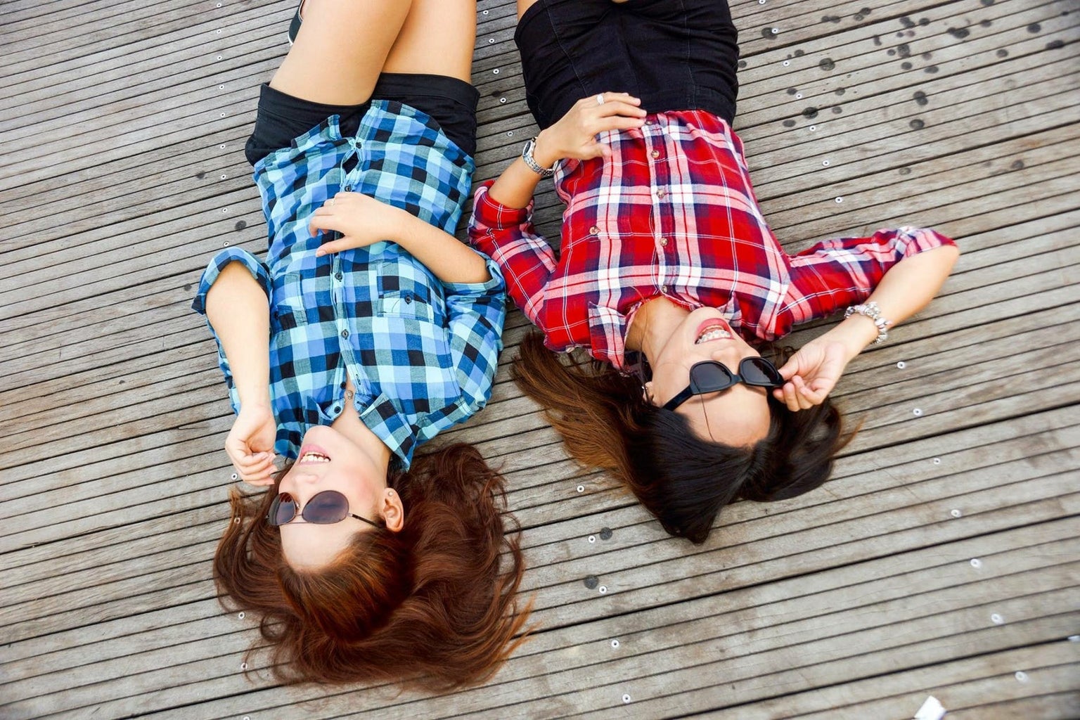 2 women laying on a deck in flannel