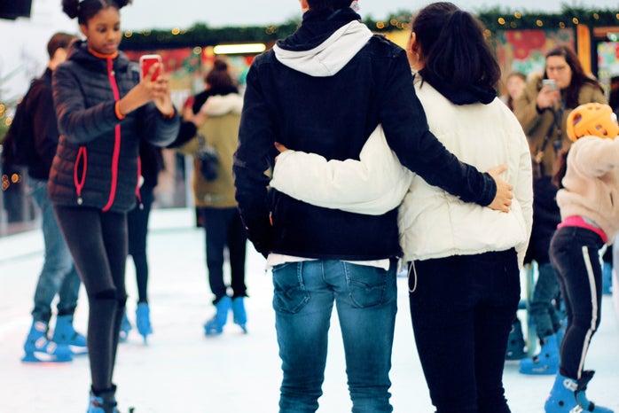 girl taking picture of a couple ice skating