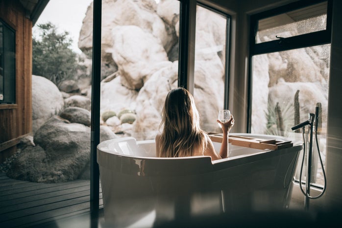 girl taking bubble bath while looking at landscape