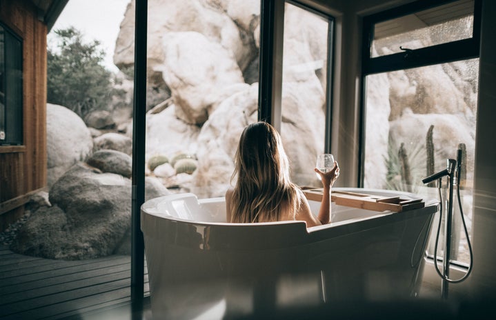 girl taking bubble bath while looking at landscape